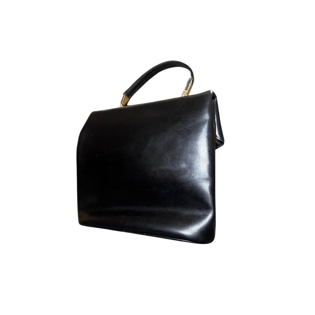 Borsa a mano vintage in pelle nera con chiusura a cerchio dorato.