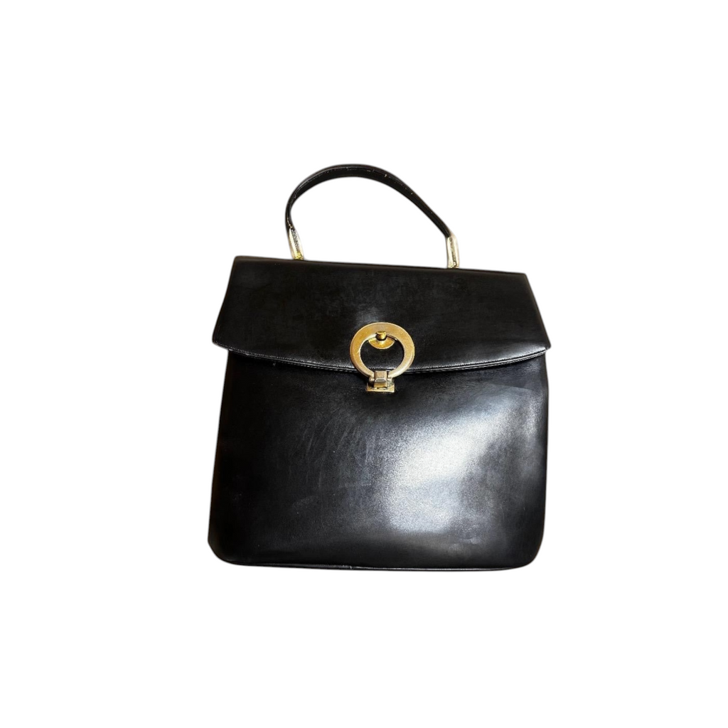 Borsa a mano vintage in pelle nera con chiusura a cerchio dorato.