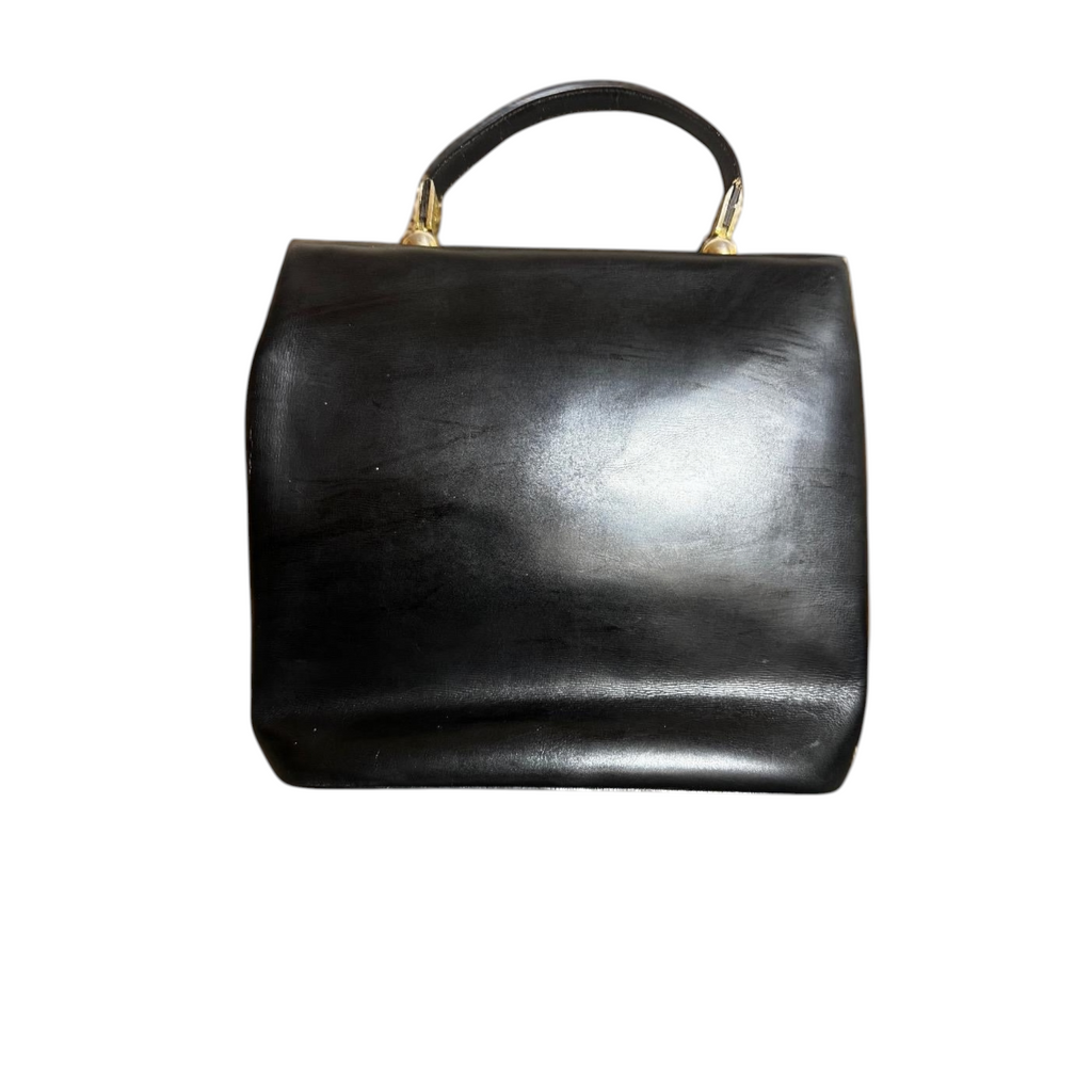 Borsa a mano vintage in pelle nera con chiusura a cerchio dorato.