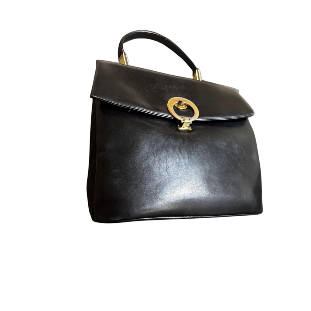 Borsa a mano vintage in pelle nera con chiusura a cerchio dorato.